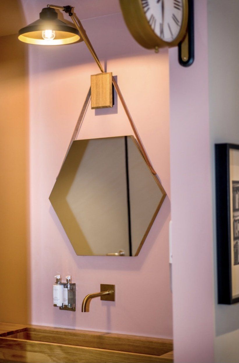 Ein Badezimmer mit einem Spiegel und einer Uhr an der Wand