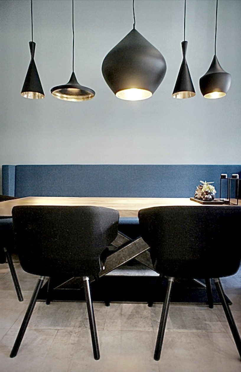 Ein Esszimmer mit Tisch und Stühlen und Pendelleuchten, die von der Decke hängen.