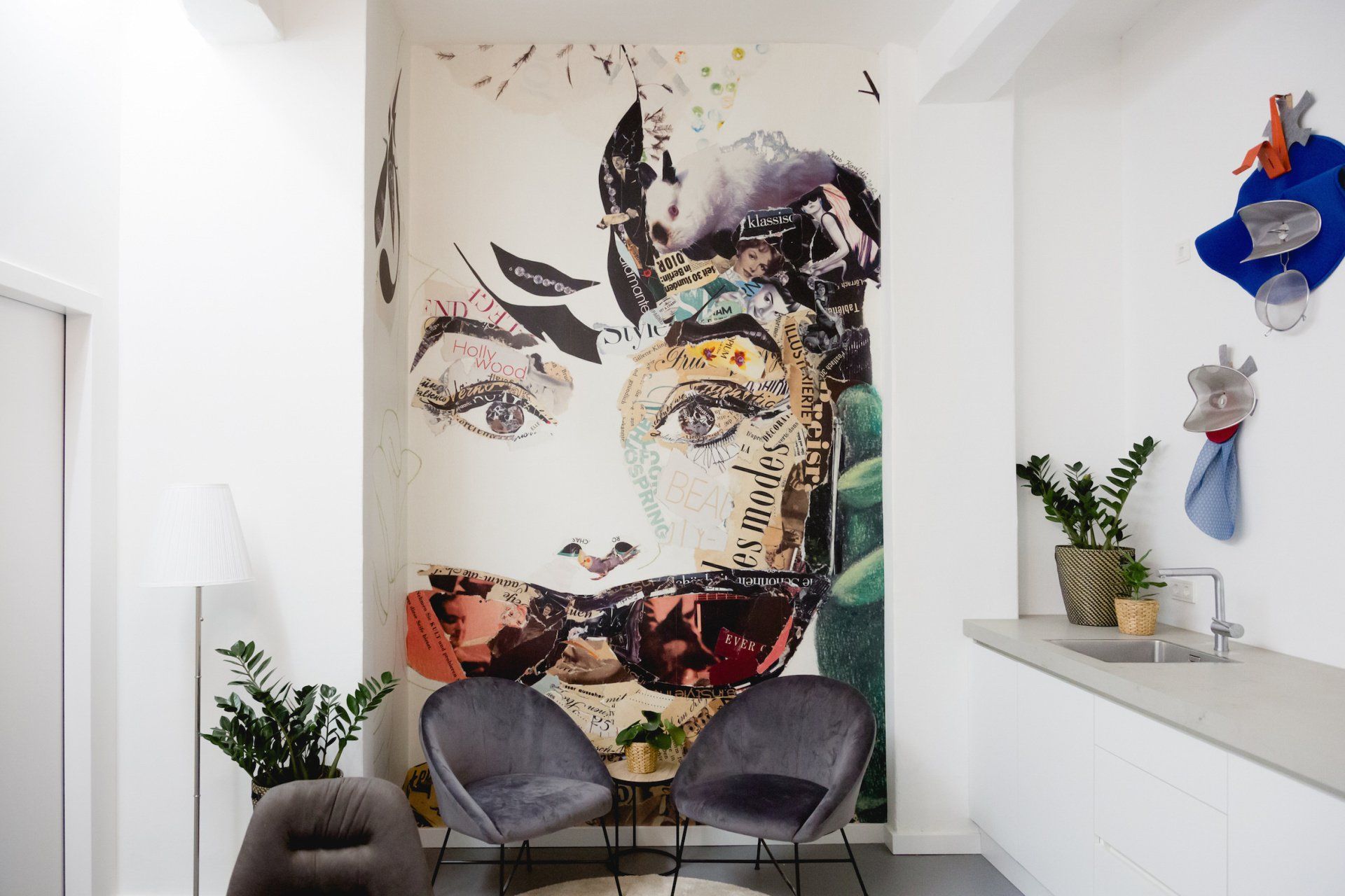 Ein Raum mit zwei Stühlen und einem Gemälde mit dem Gesicht einer Frau an der Wand.