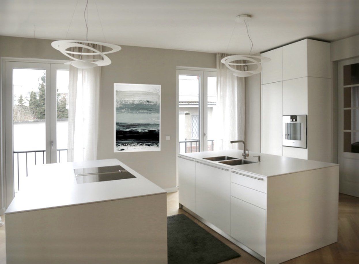 Eine Küche mit weißen Schränken und einer großen Insel