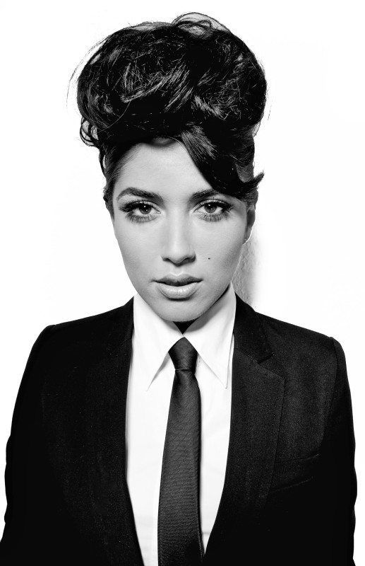 Ein Schwarzweißfoto einer Frau in Anzug und Krawatte