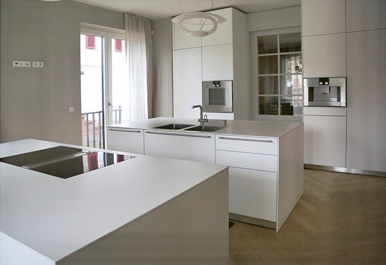 Eine Küche mit weißen Schränken und Geräten aus Edelstahl