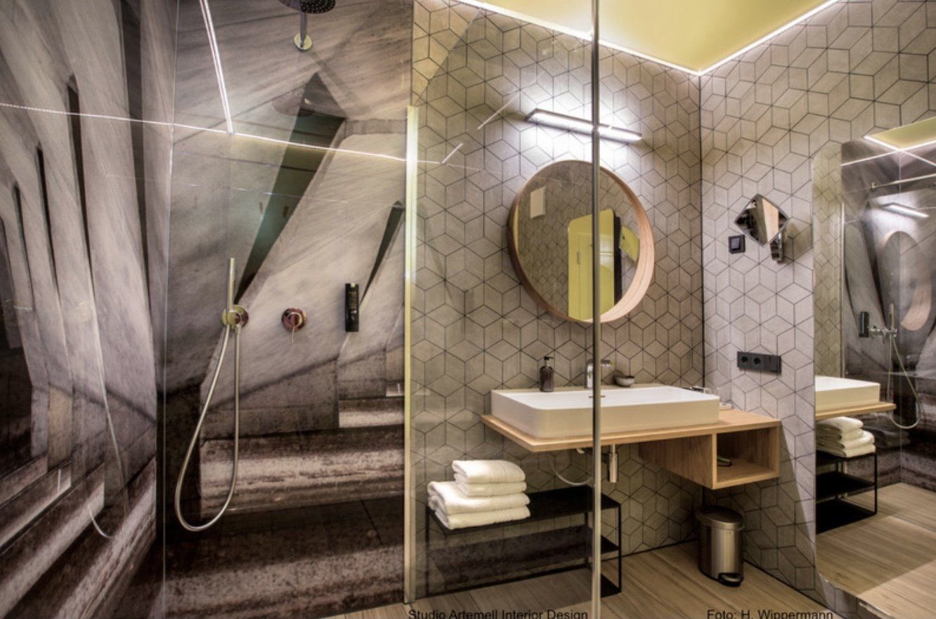 Ein Badezimmer mit zwei Waschbecken, einer Dusche und einem Spiegel.