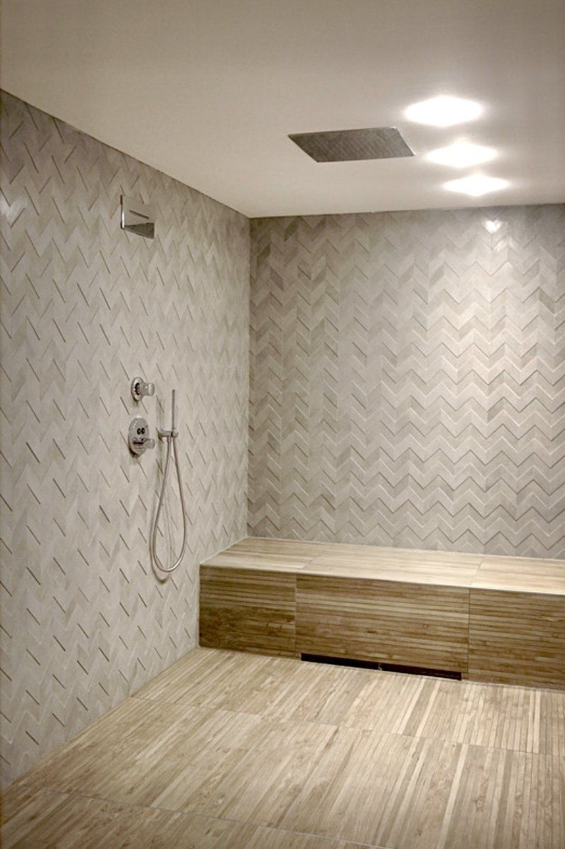 Ein Badezimmer mit Dusche und Sitzbank darin.