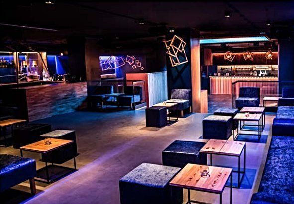 Es gibt viele Tische und Stühle im Raum.