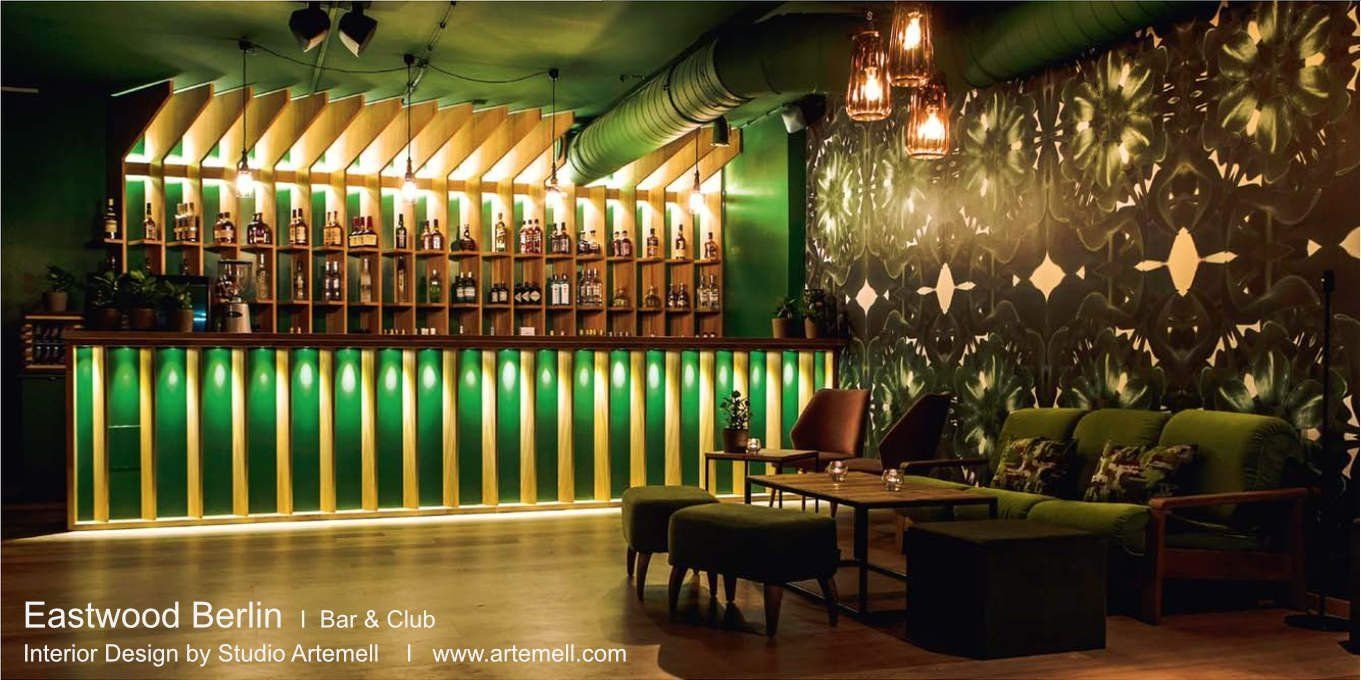 Ein Wohnzimmer mit grünen Möbeln und einer Bar im Hintergrund.