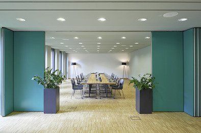 Ein großer Konferenzraum mit einem langen Tisch und Stühlen.