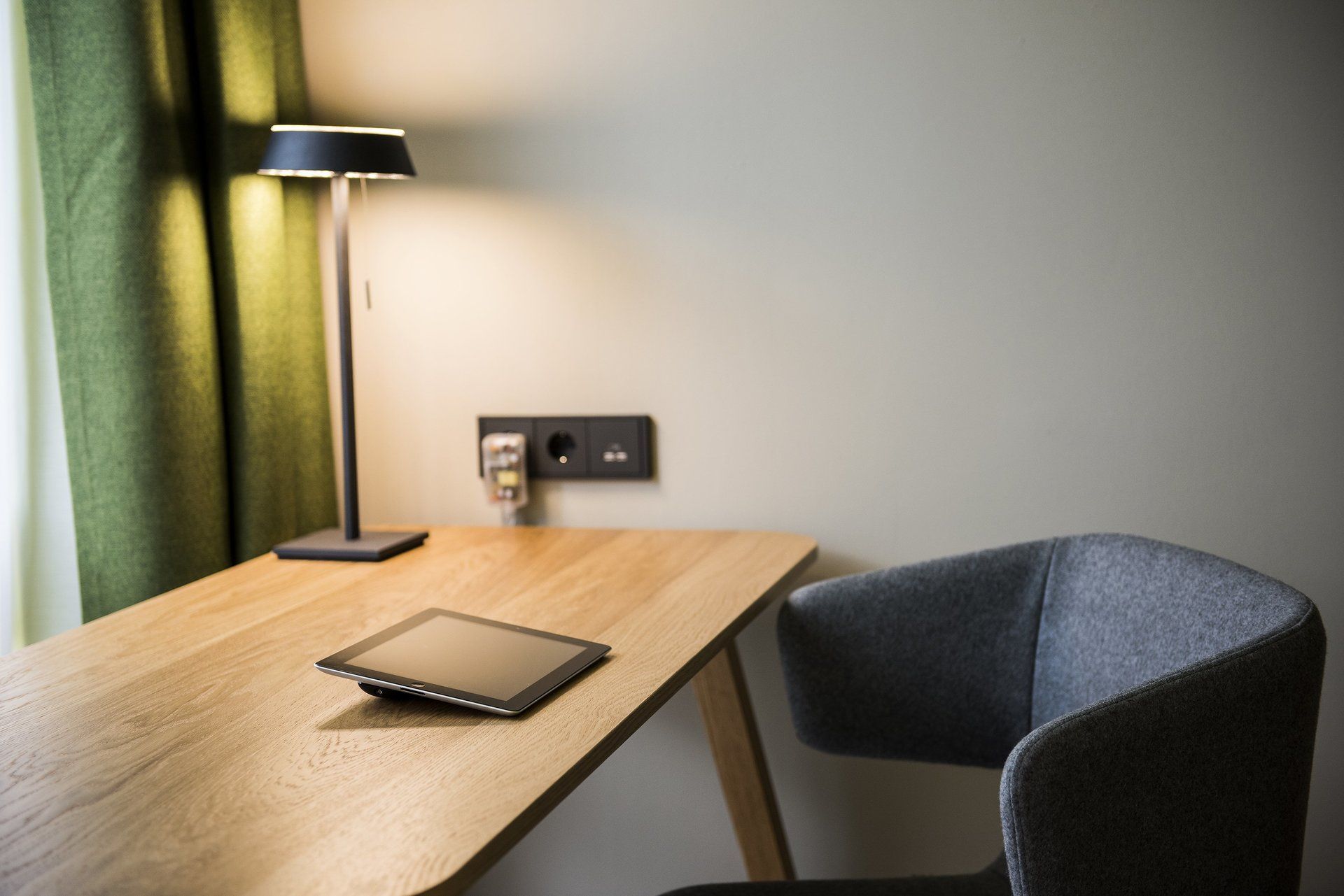 Ein Schreibtisch mit einer Lampe und einem Tablet darauf