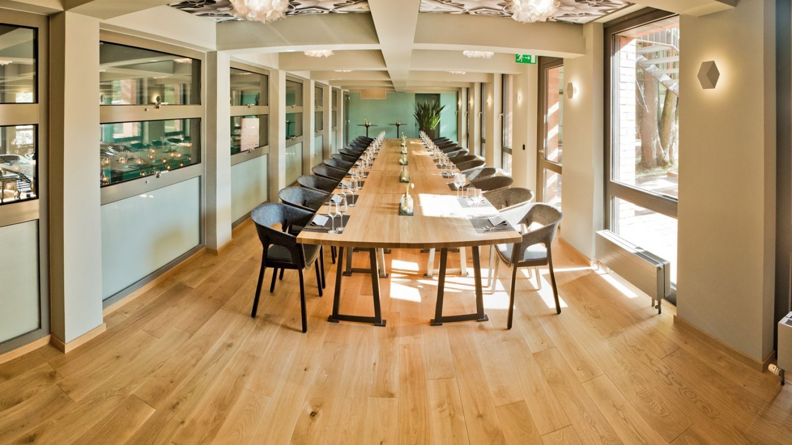 Ein großer Raum mit einem langen Tisch und Stühlen darin.