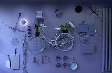 An einer violetten Wand hängt ein weißes Fahrrad.