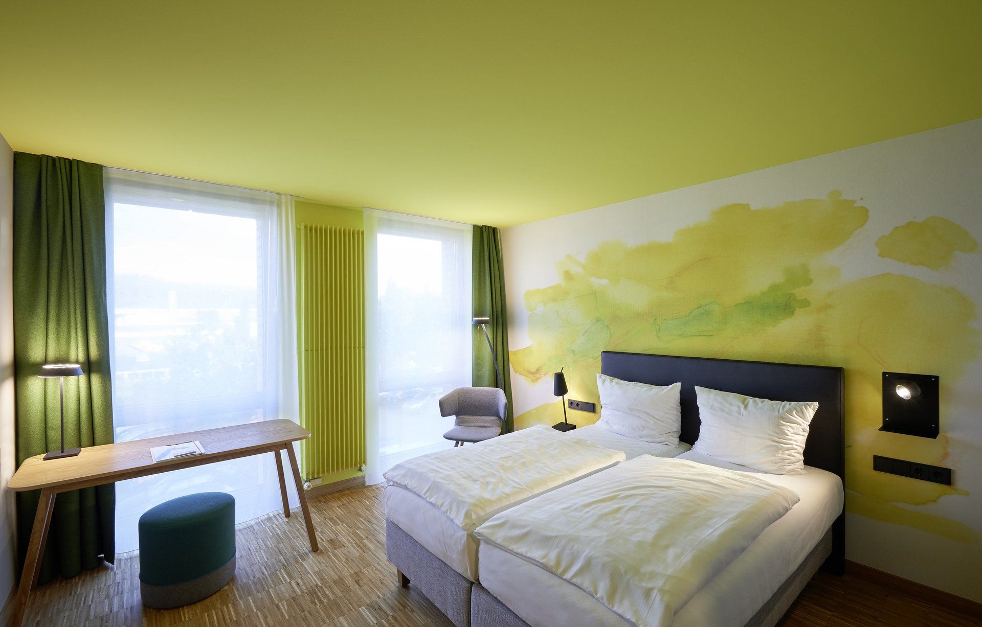 Ein Hotelzimmer mit zwei Betten, einem Schreibtisch und einem Stuhl.