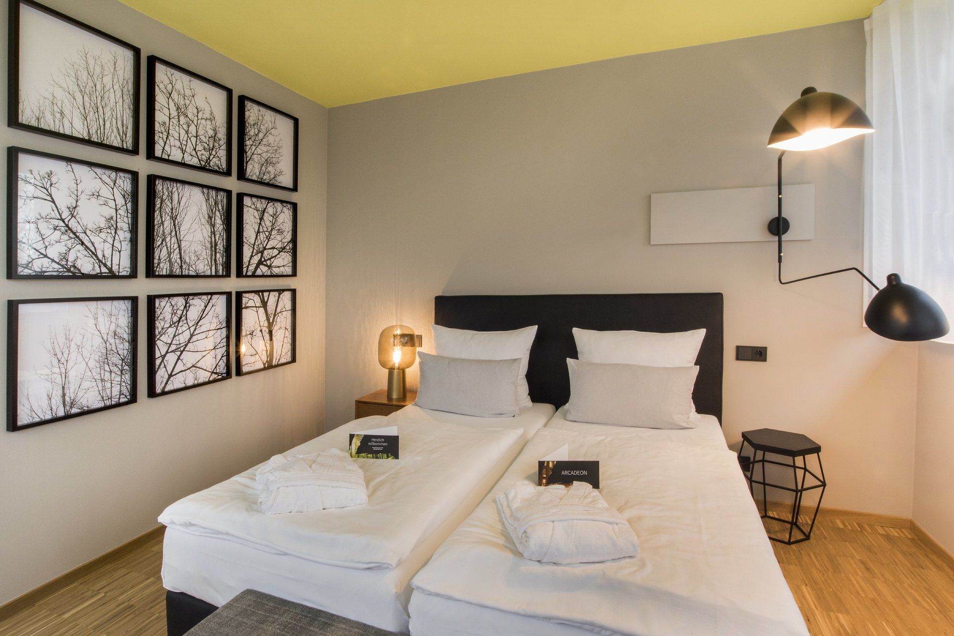 Ein Schlafzimmer mit zwei Betten, einer Lampe und Bildern an der Wand.