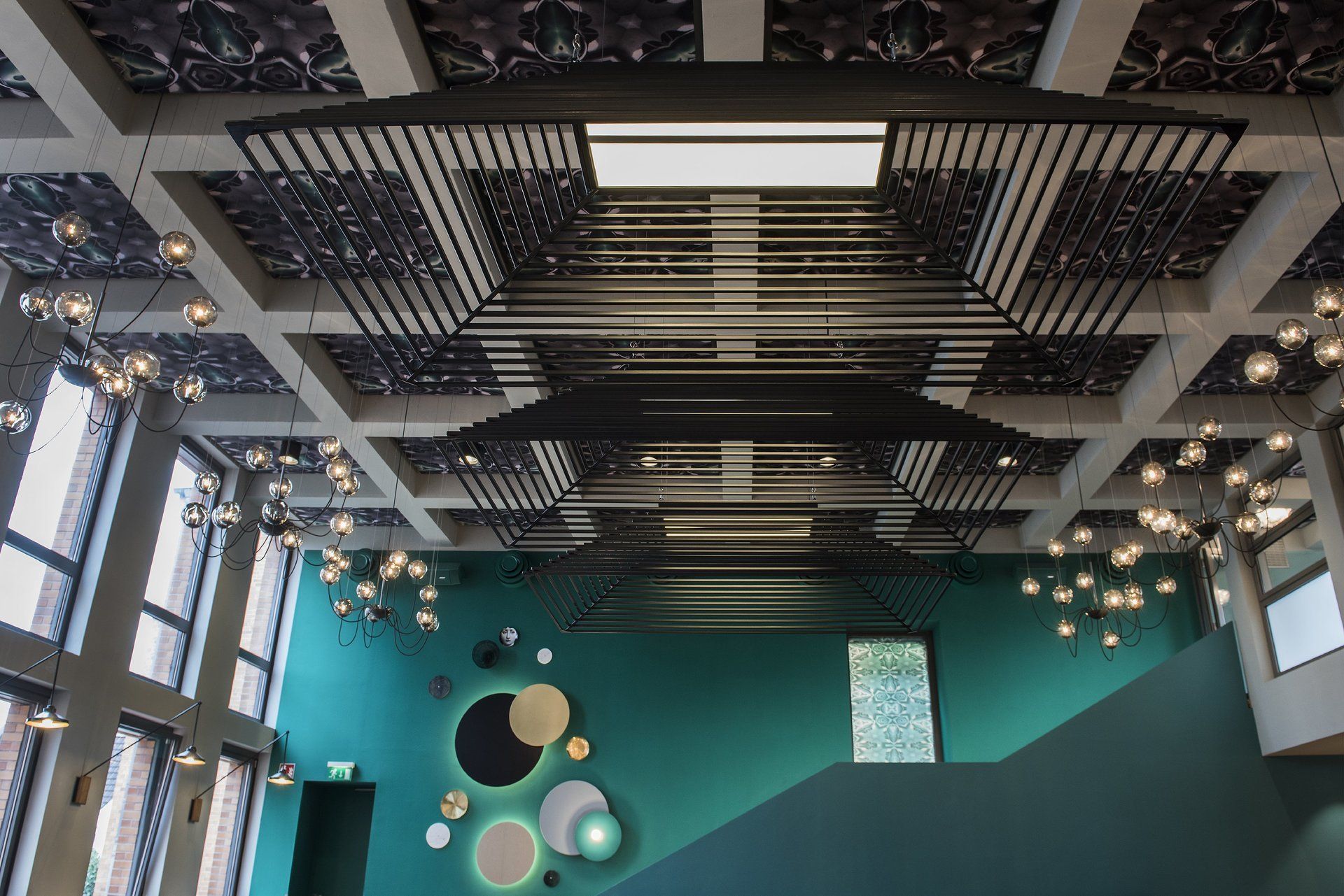 Ein großer Raum mit einer blauen Wand und einer Decke, von der viele Lichter hängen.