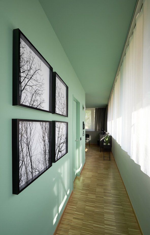 Ein langer Flur mit Bildern an der Wand und einem Holzboden.