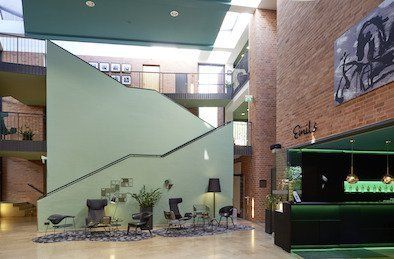 Eine Lobby eines Gebäudes mit Treppen und Stühlen