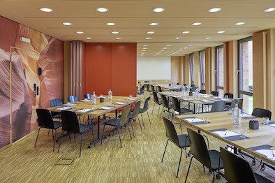 Ein großer Konferenzraum mit Tischen und Stühlen für eine Besprechung.