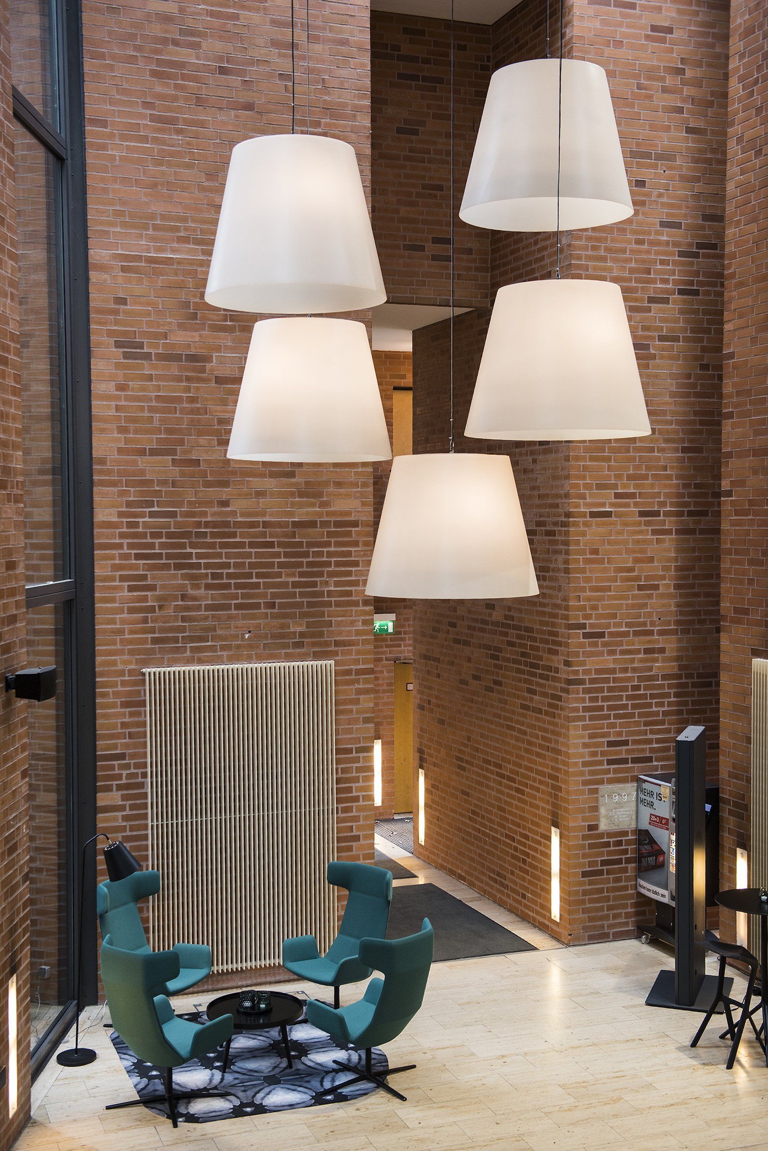 Ein Raum mit einer Ziegelwand und weißen Lampen, die von der Decke hängen