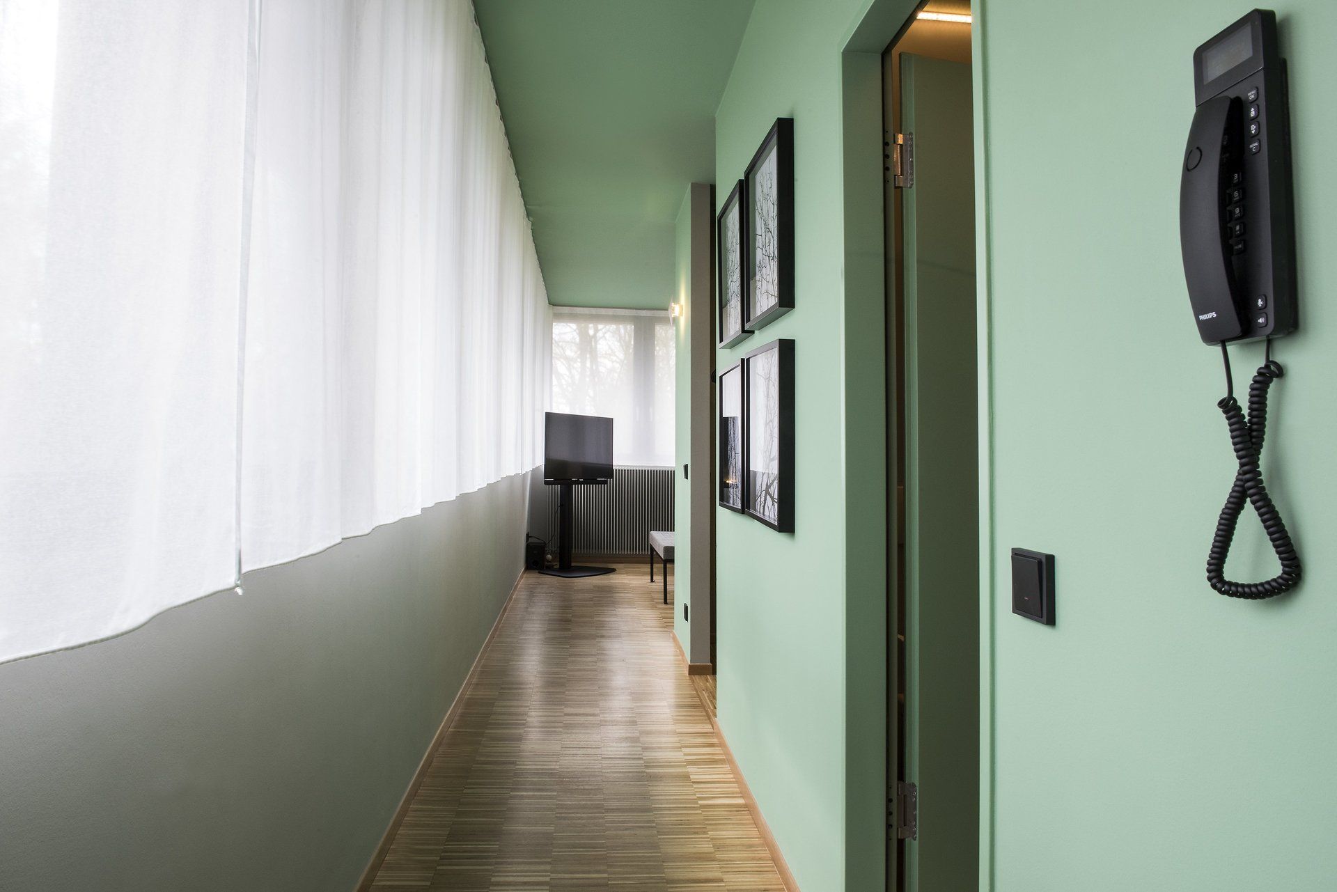 Ein langer Flur mit einem Telefon an der Wand.