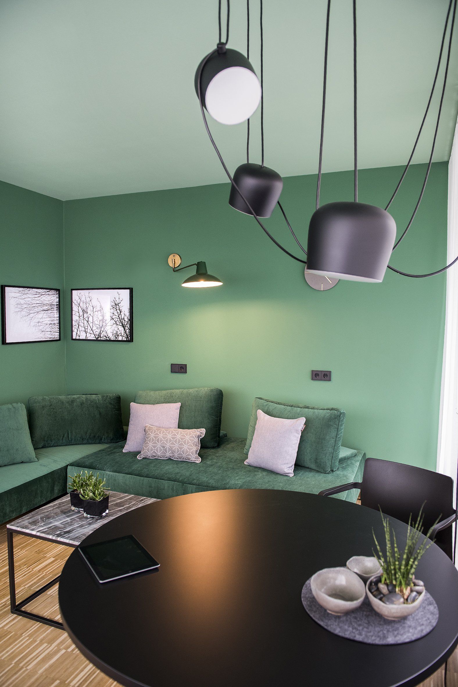Ein Wohnzimmer mit grünen Wänden und einem schwarzen Tisch.