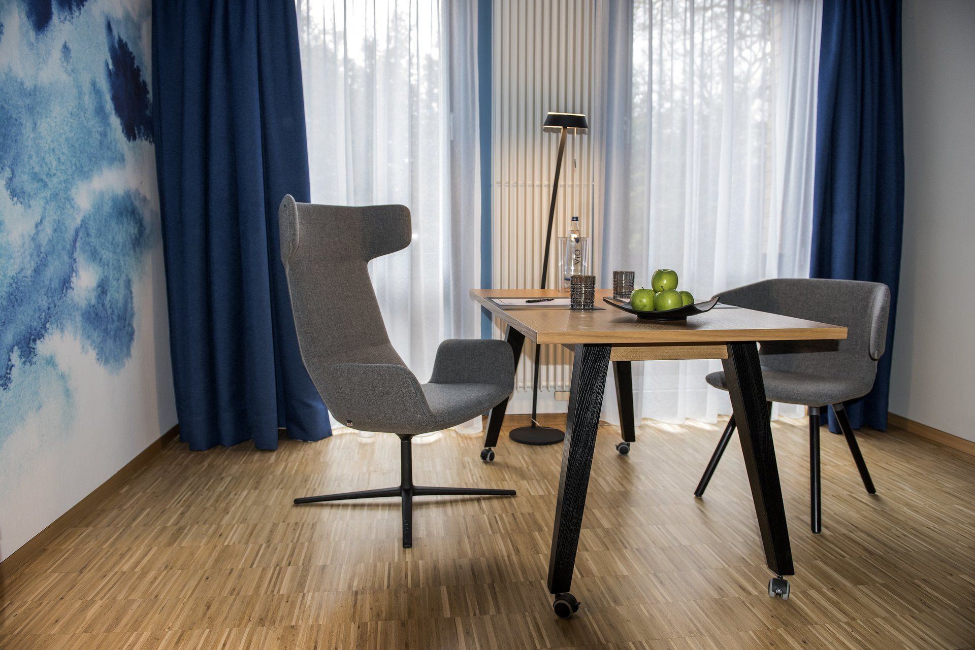 Ein Raum mit einem Tisch und Stühlen vor einem Fenster.