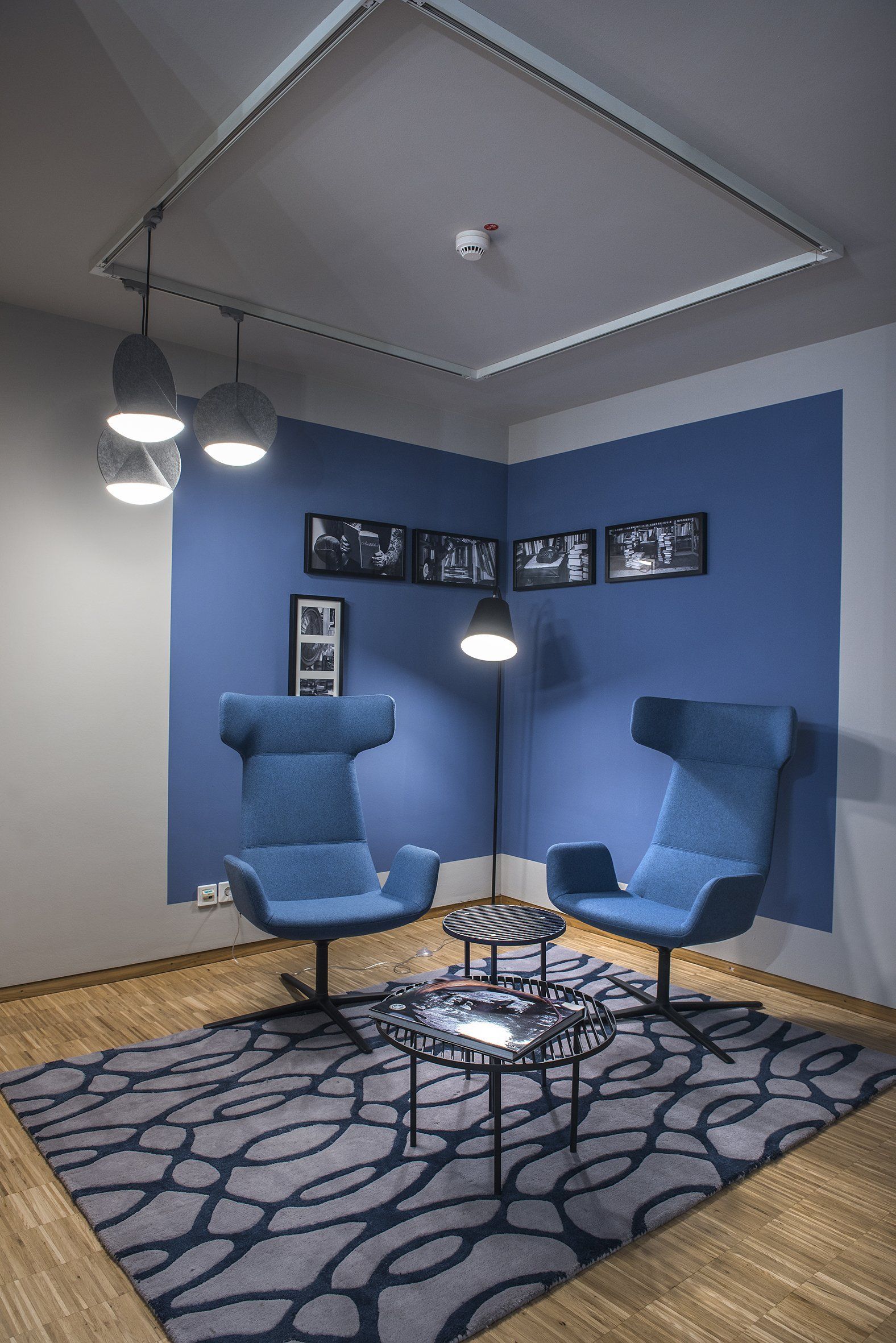 In einem Raum mit blauen Wänden stehen zwei blaue Stühle.