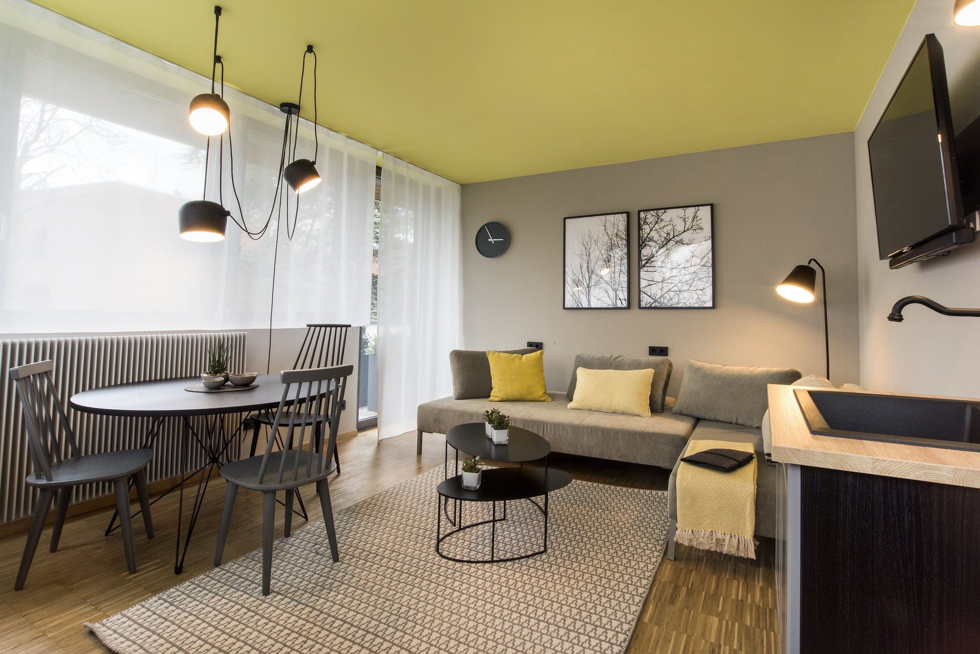 Ein Wohnzimmer mit Couch, Tisch, Stühlen und Fernseher.