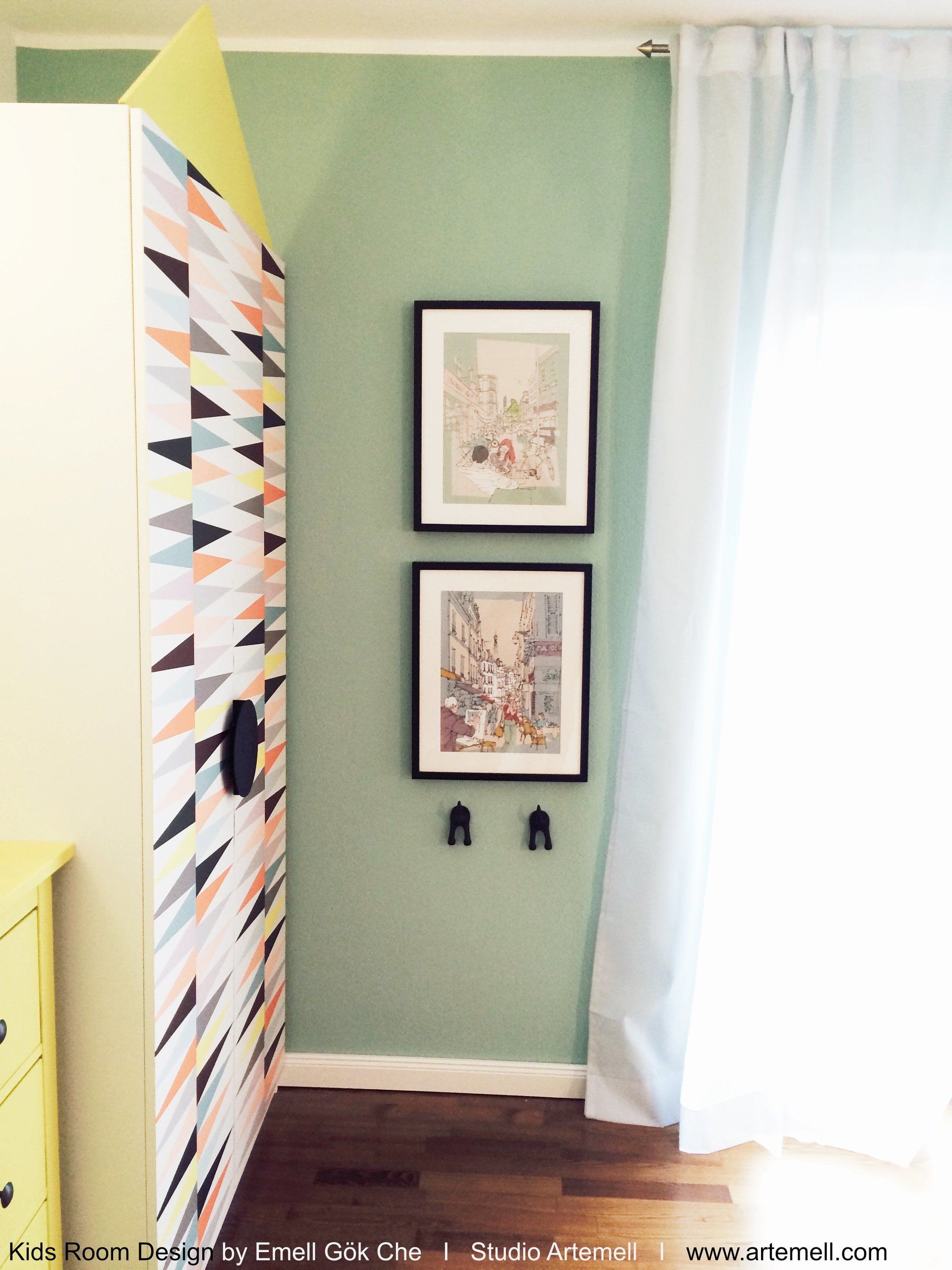 Ein Zimmer mit grünen Wänden und zwei Bildern an der Wand.