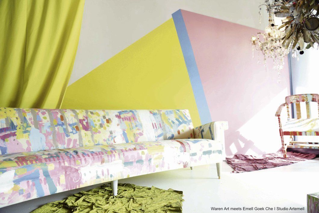 Ein Wohnzimmer mit einer bunten Couch und einem Sessel