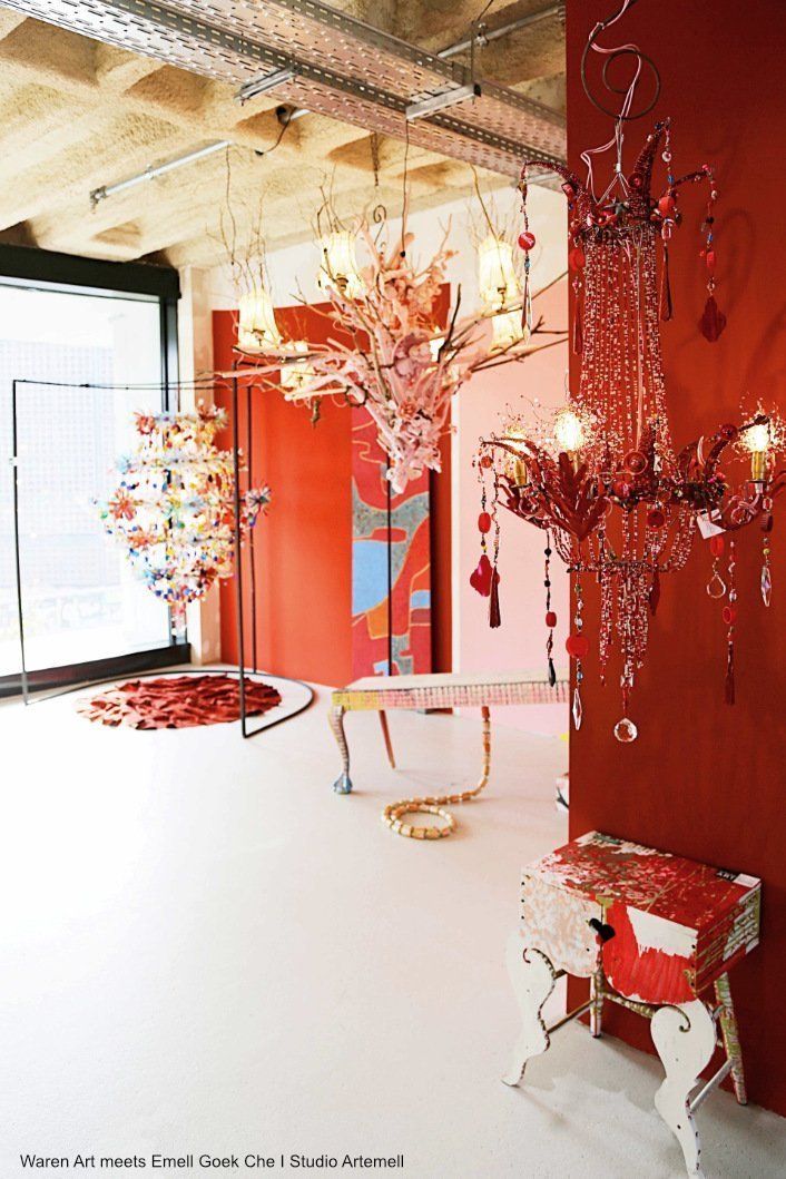 Ein Raum mit roten Wänden, einem Tisch und einem Kronleuchter, der von der Decke hängt.