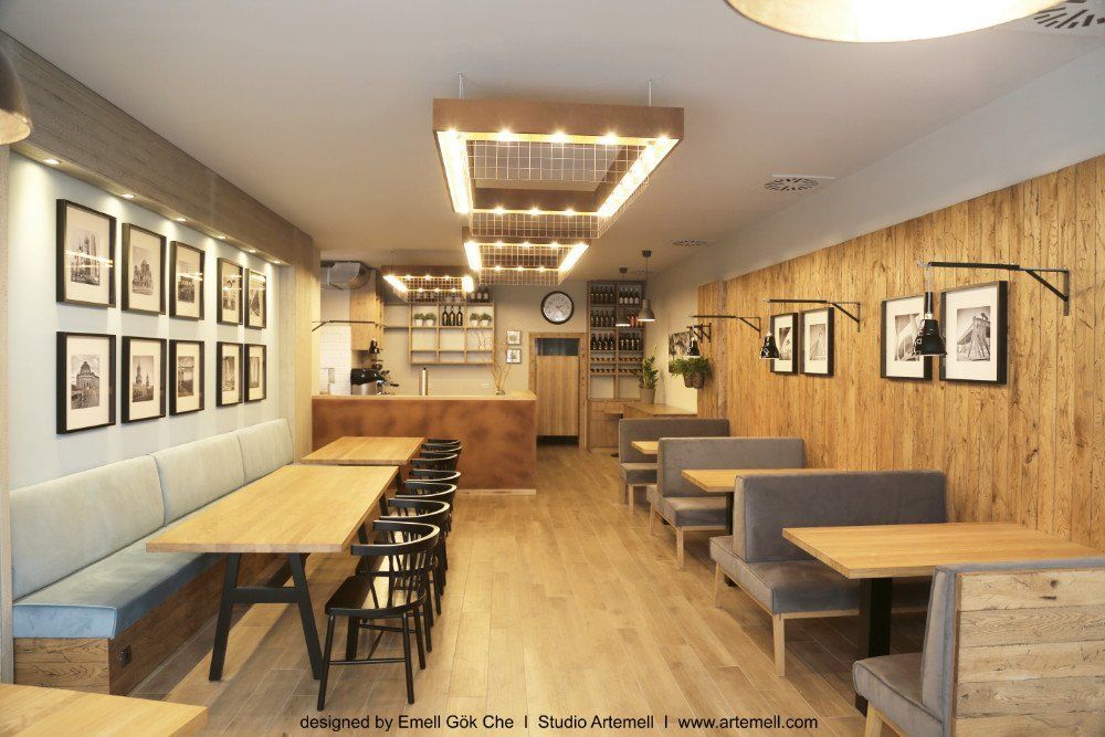 Ein Restaurant mit Holztischen und Bänken und Bildern an den Wänden.