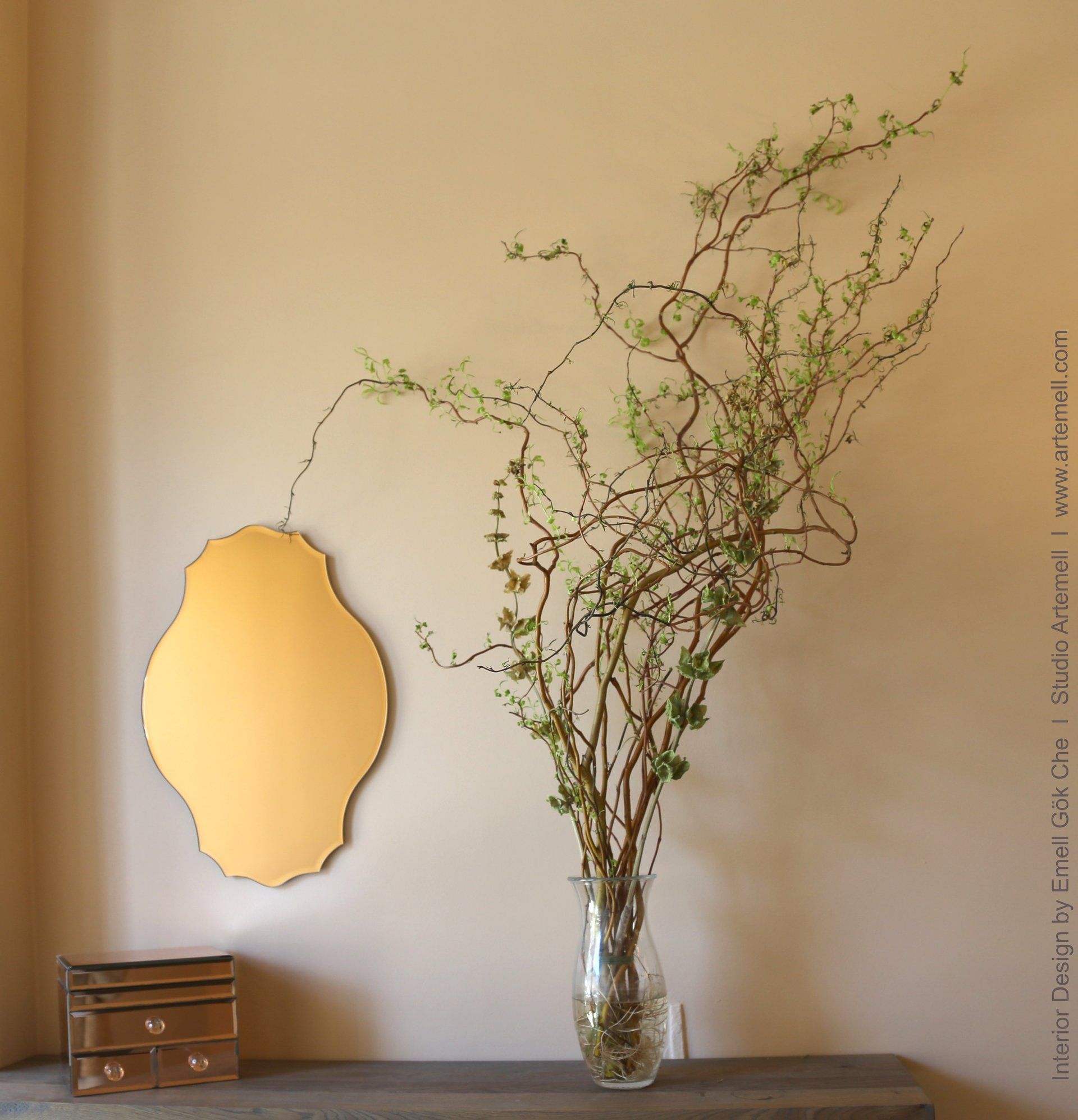 Eine Vase mit Blumen steht auf einem Tisch neben einem Spiegel