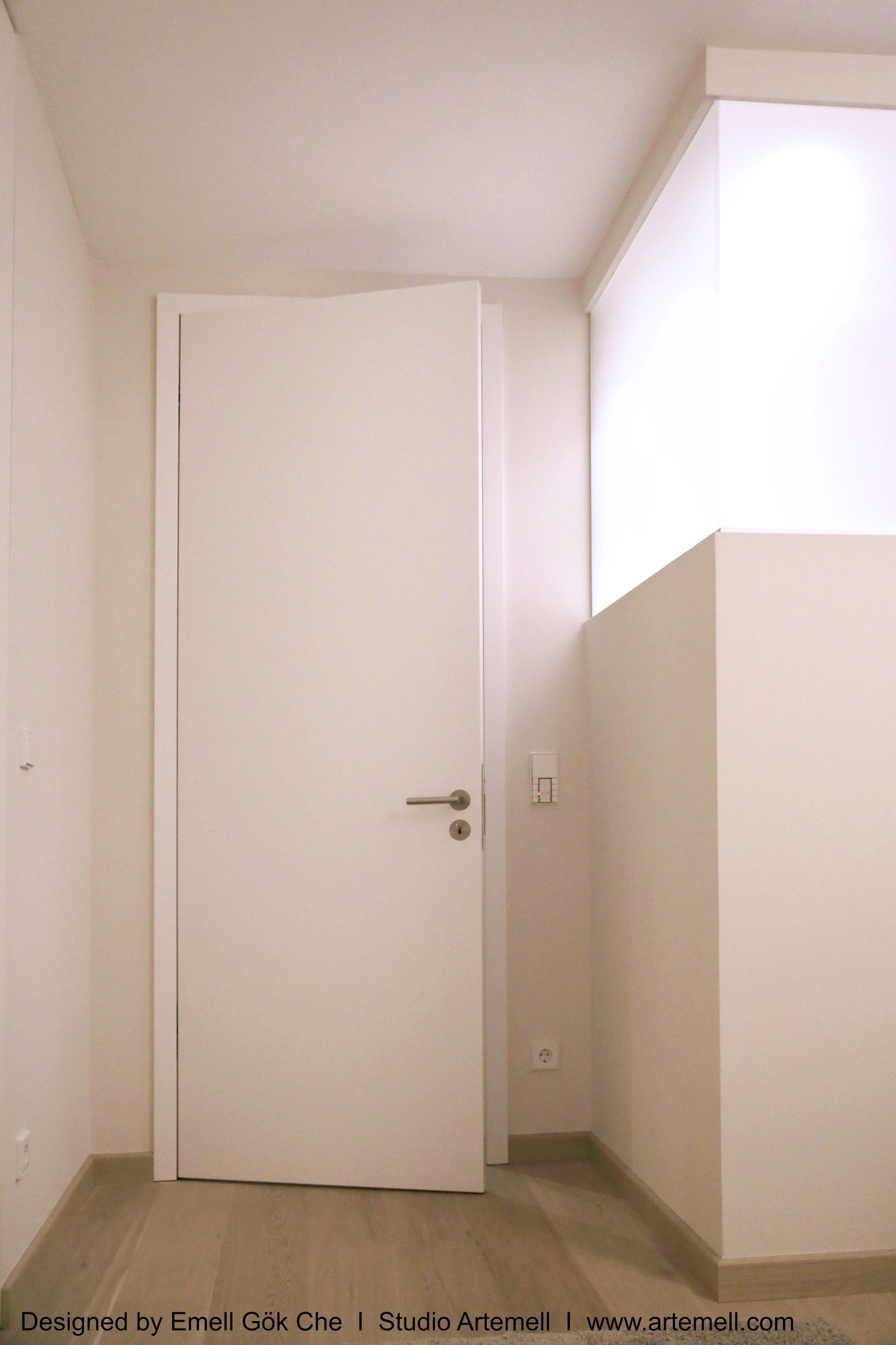 Ein Flur mit einer weißen Tür und einem Fenster