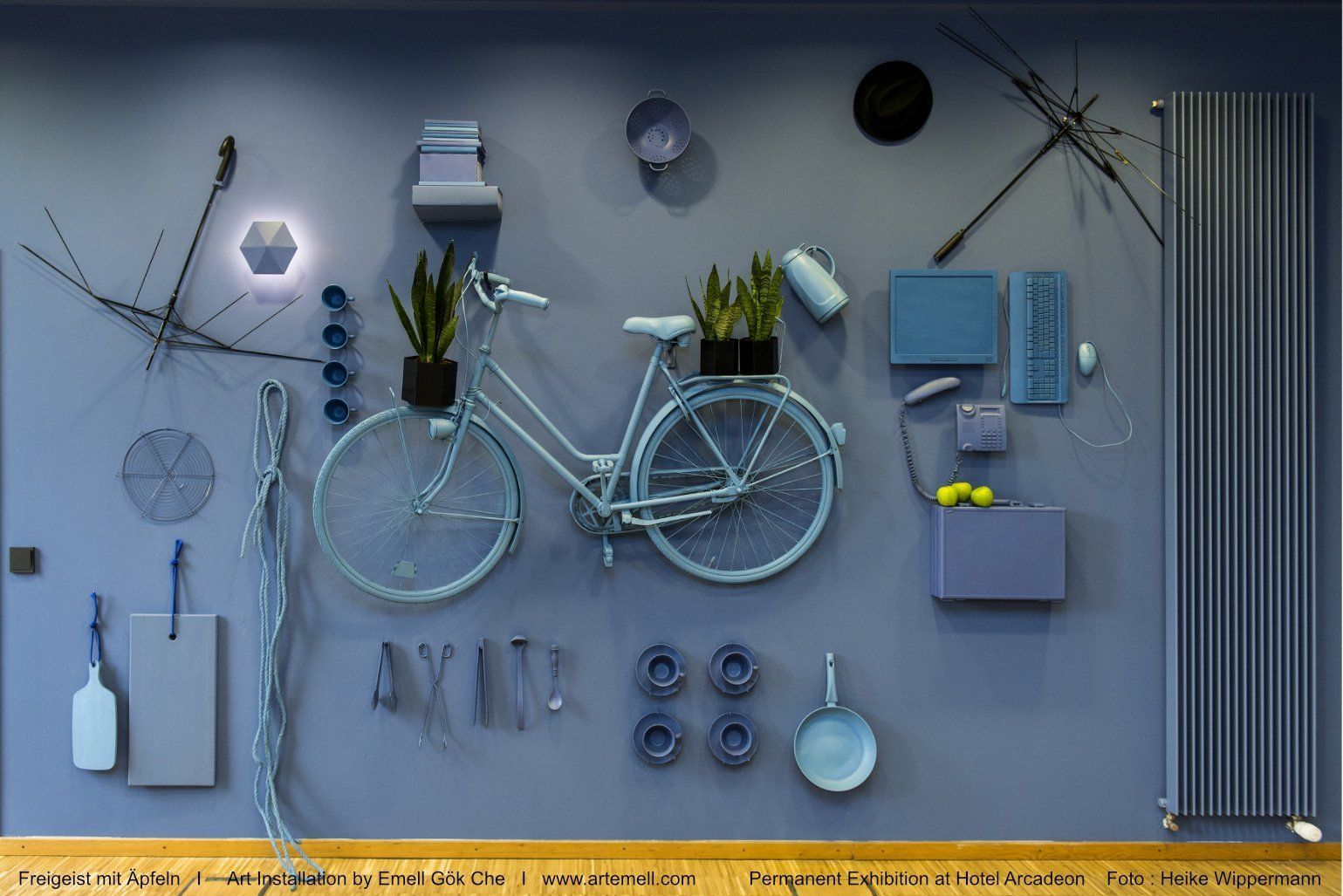 Ein Fahrrad hängt, umgeben von verschiedenen Gegenständen, an einer Wand.