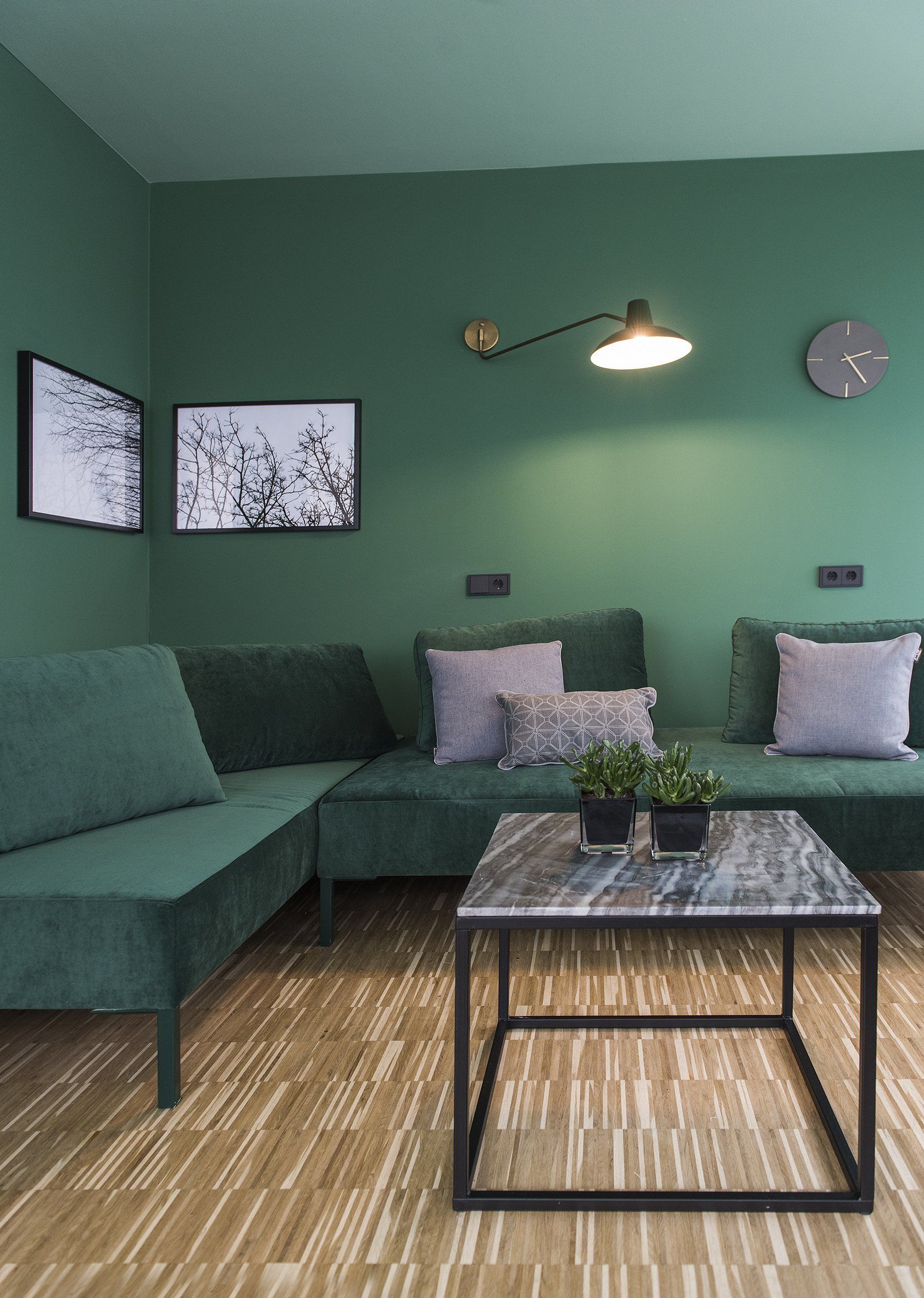 Ein Wohnzimmer mit grünen Wänden, grünen Möbeln und einem Couchtisch.