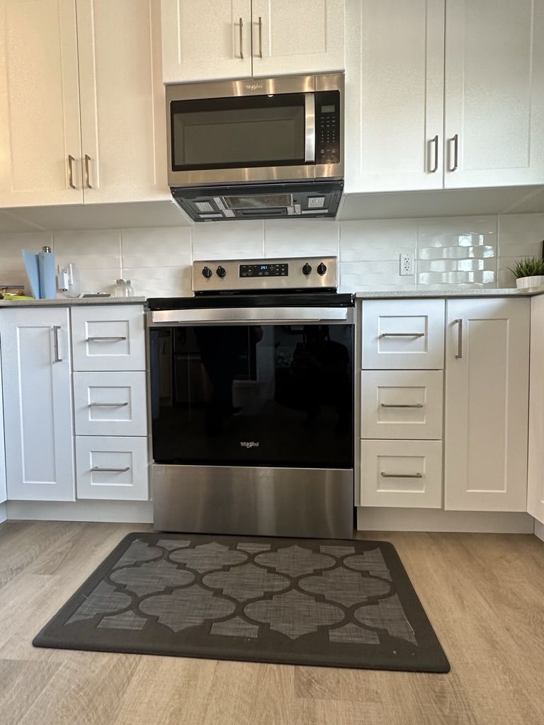 A kitchen with stainless steel appliances and white cabinets