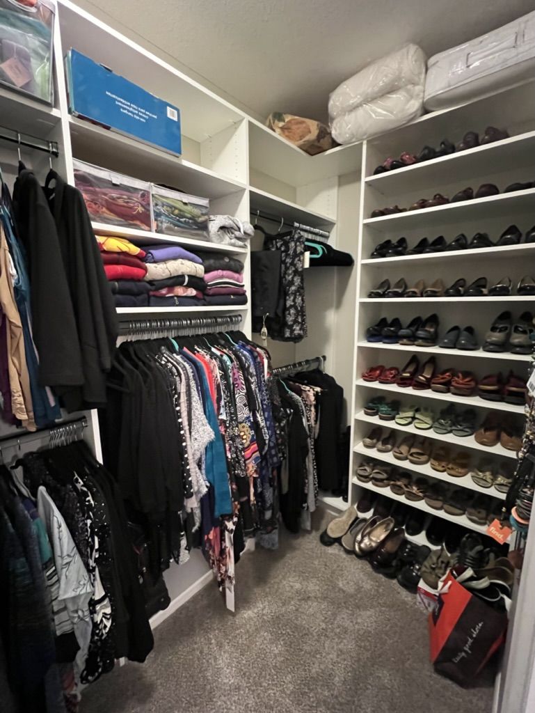 A walk in closet filled with clothes and shoes.