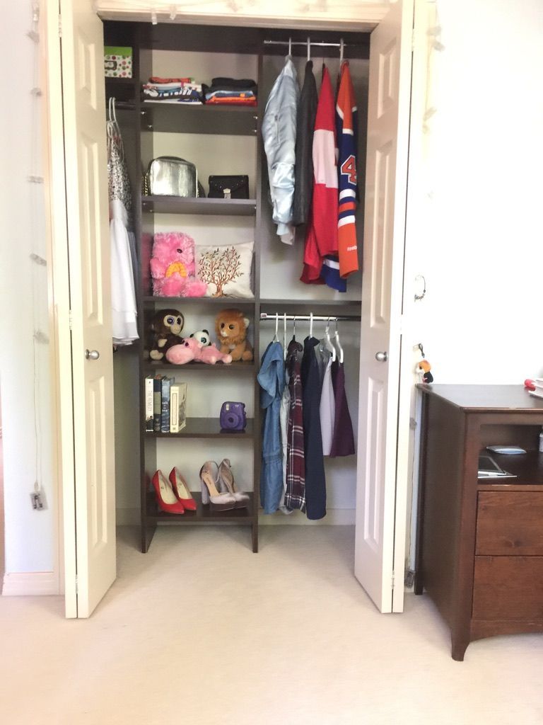 A bedroom with a closet filled with clothes and shoes