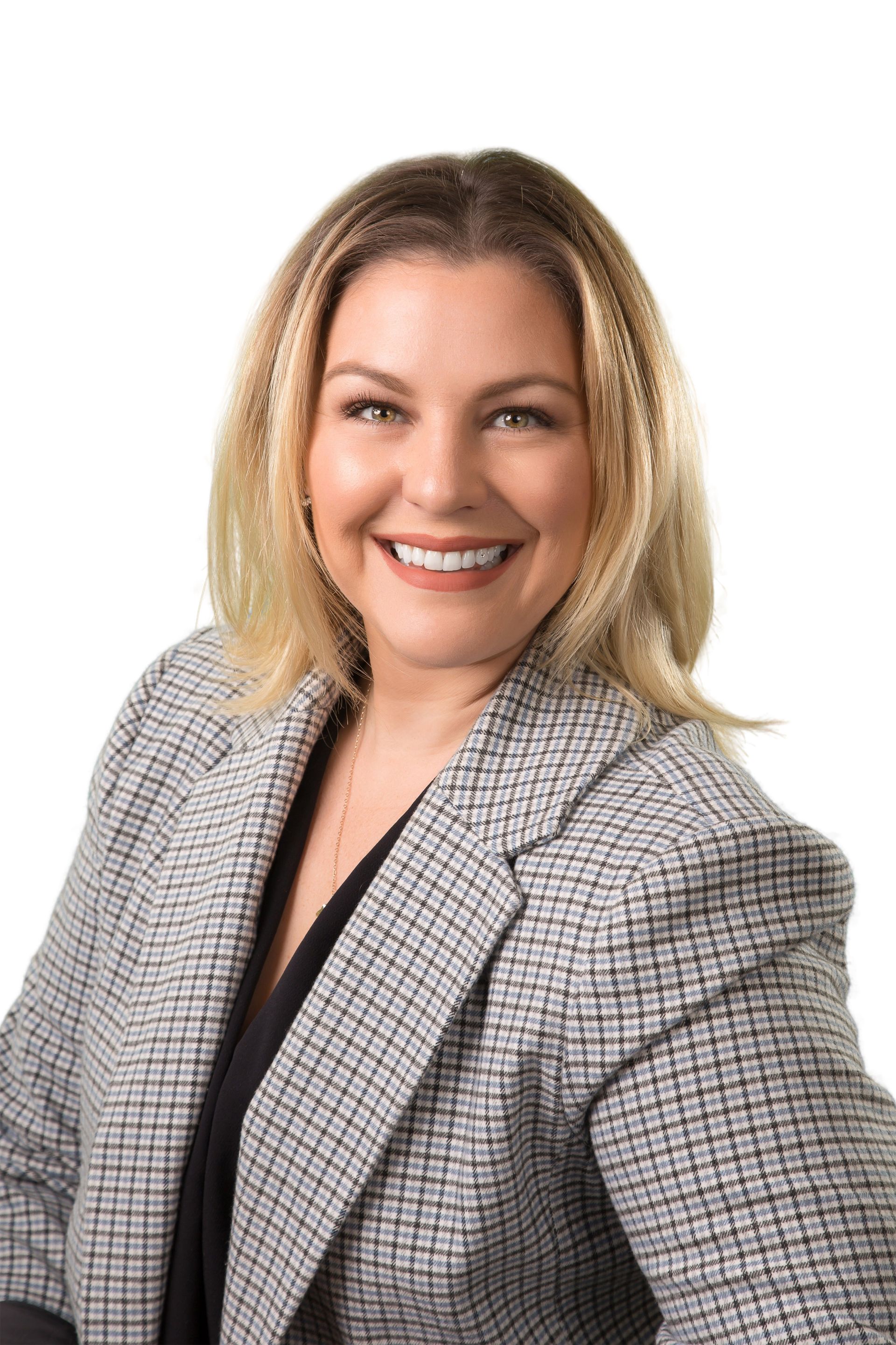 A woman in a plaid jacket is smiling for the camera.