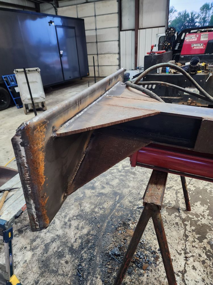 A piece of metal is sitting on a wooden table in a garage.