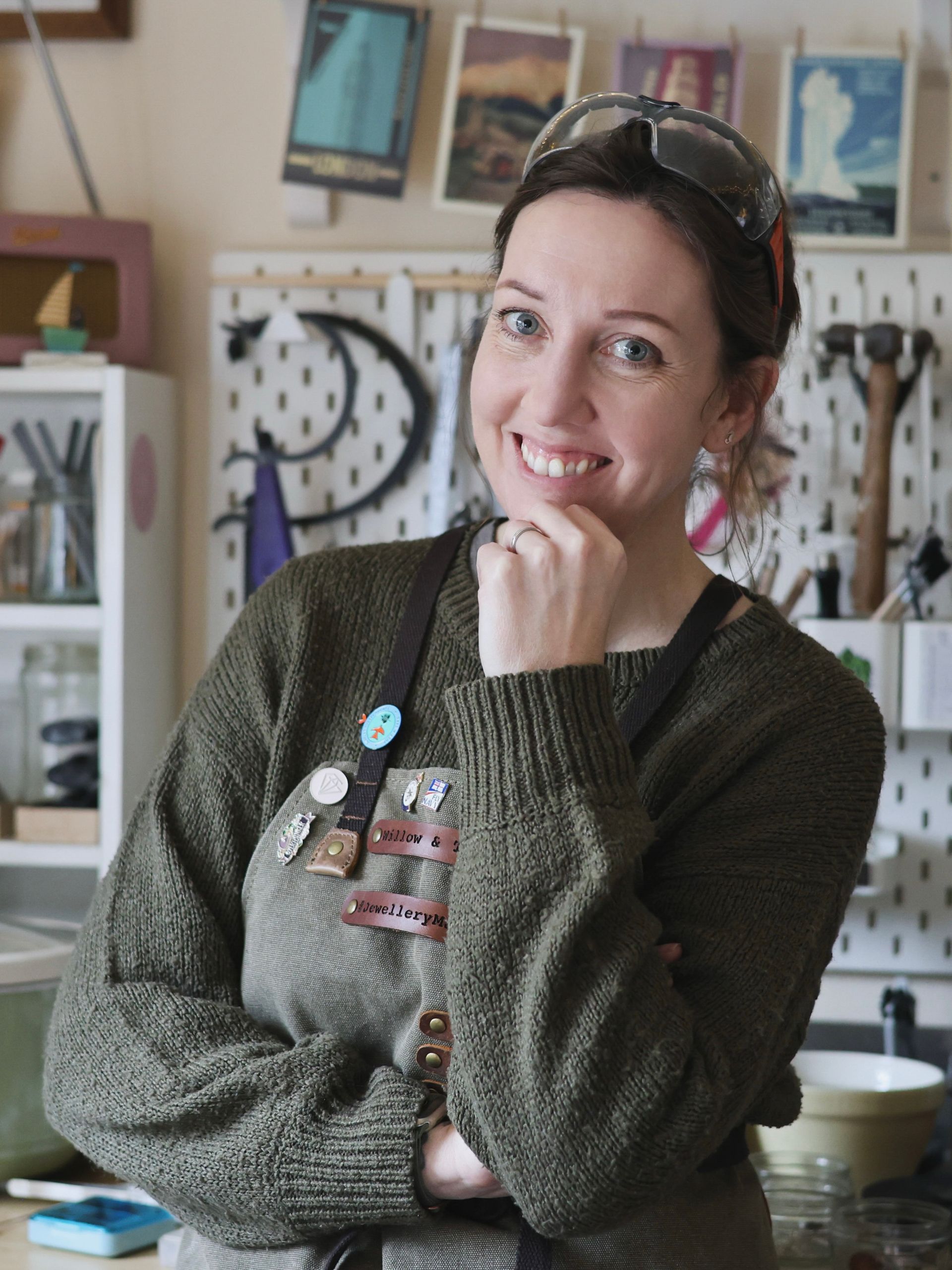 A photo of Kelly Twigg from Willow and Twigg Jewellery, in her workshop wearing a green canvas apron.