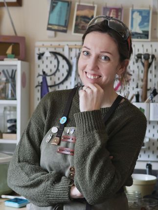 A photo of Kelly Twigg from Willow and Twigg Jewellery, in her workshop wearing a green canvas apron.