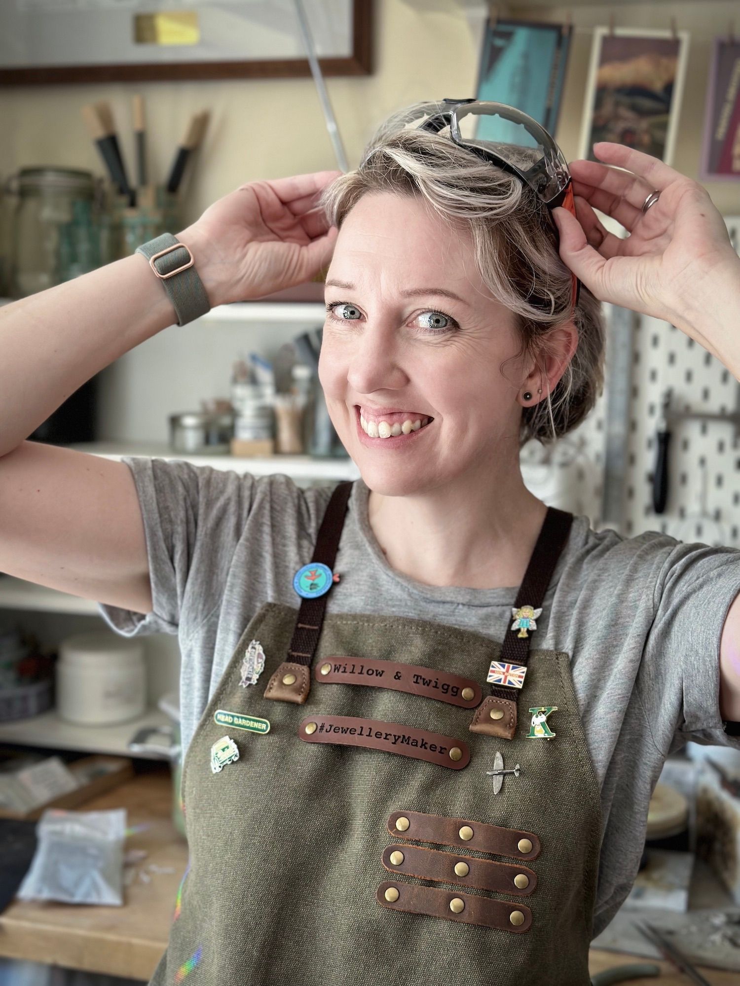 A photo of Kelly Twigg from Willow and Twigg Jewellery, in her workshop wearing a green canvas apron.