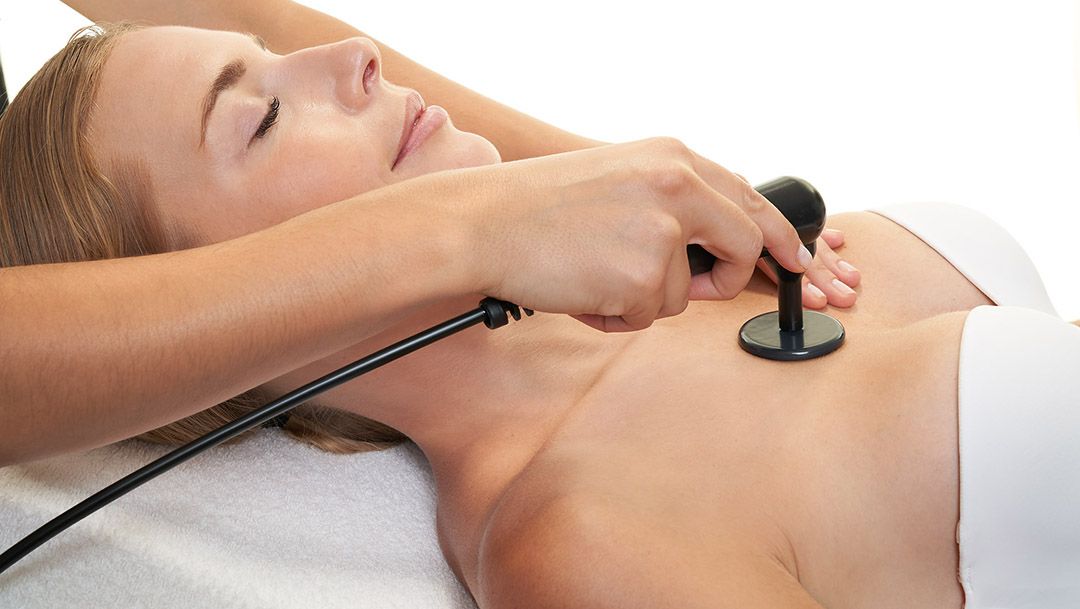 A woman is getting a massage with a stethoscope on her chest.