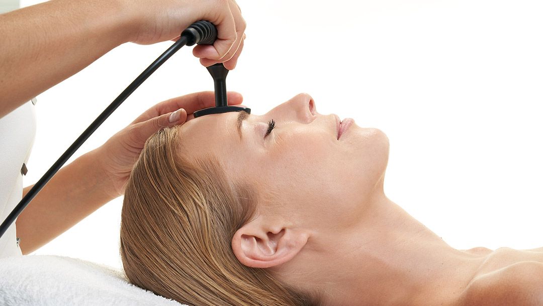 A woman is getting a facial treatment at a spa.