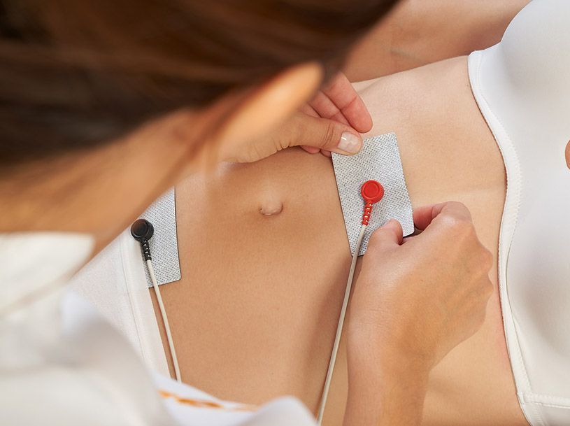 A woman is getting an electrocardiogram from a doctor