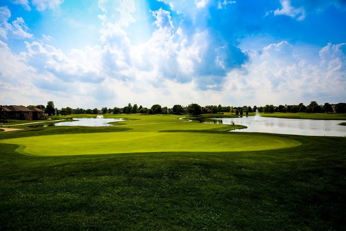 A golf course with a lake in the middle of it.