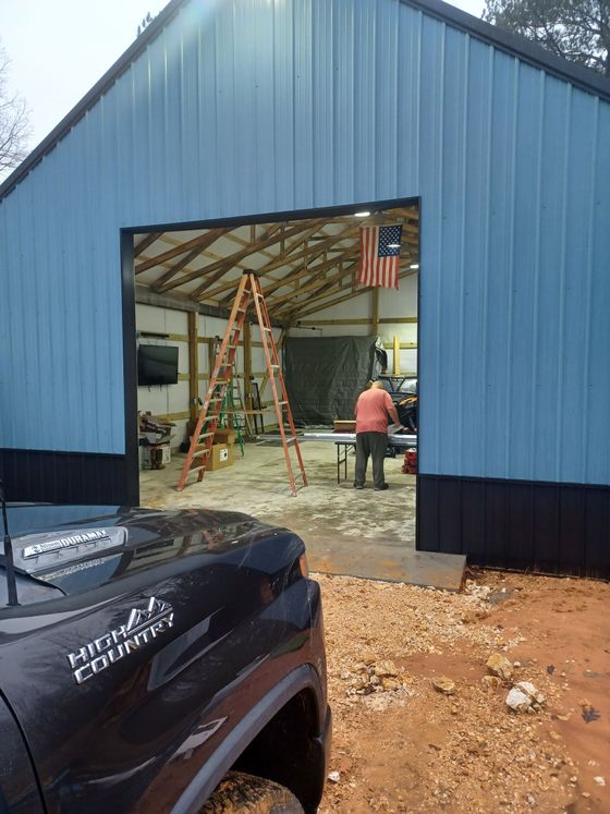 A black truck is parked in front of a blue building