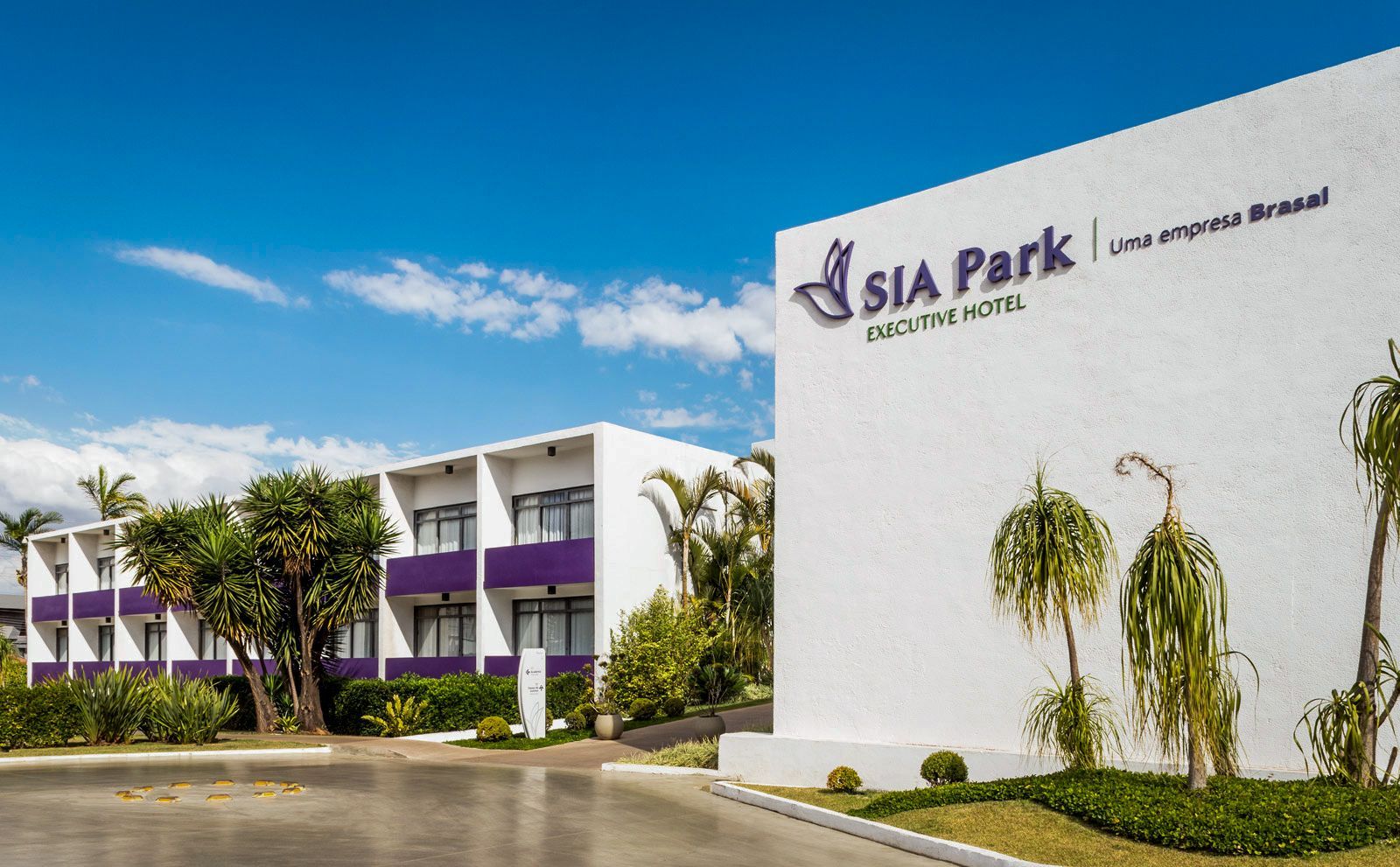 Um grande edifício branco com uma varanda roxa é iluminado à noite