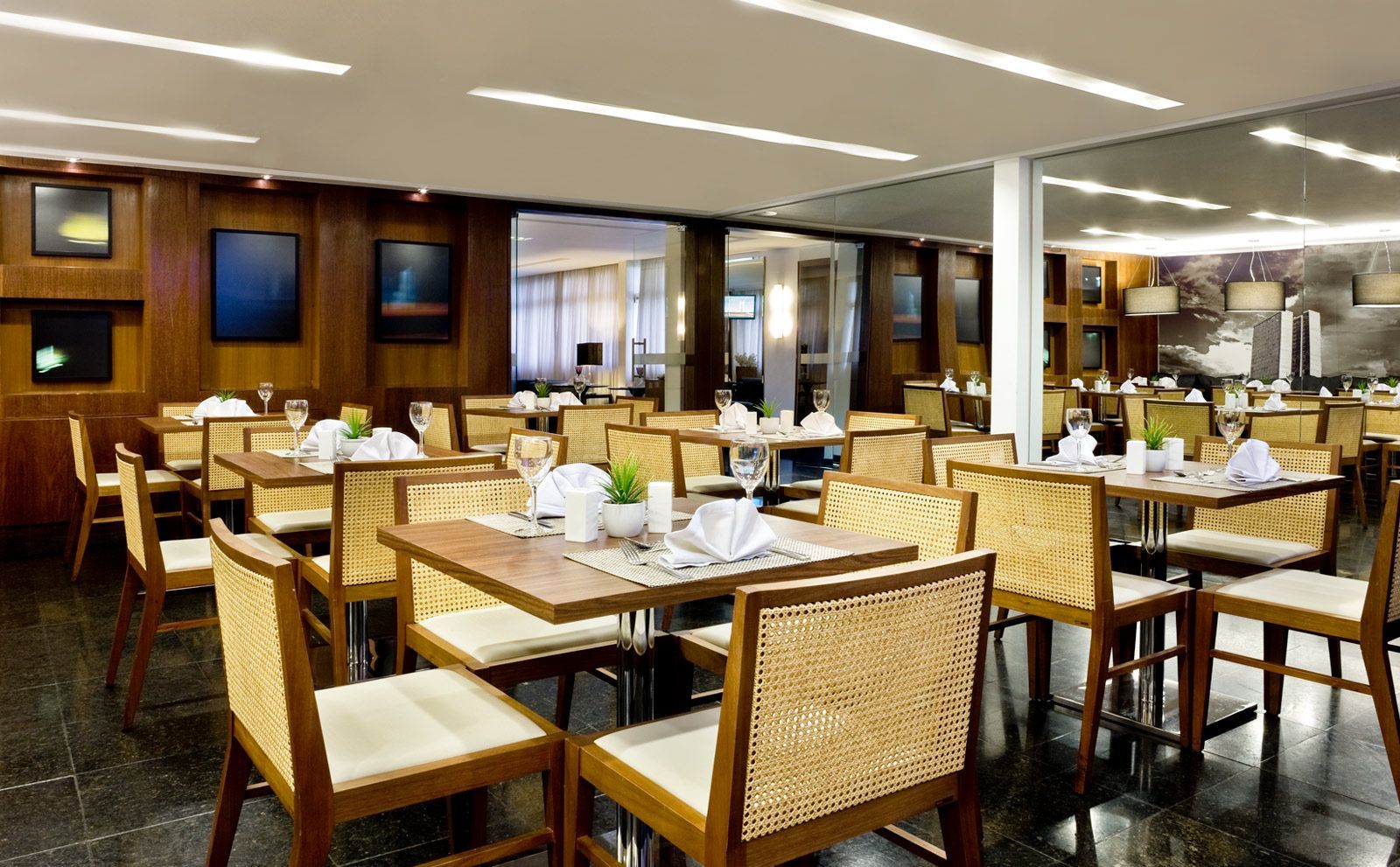 Um restaurante com mesas e cadeiras preparadas para o jantar