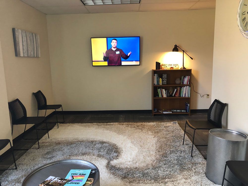 A waiting room with a flat screen tv on the wall.